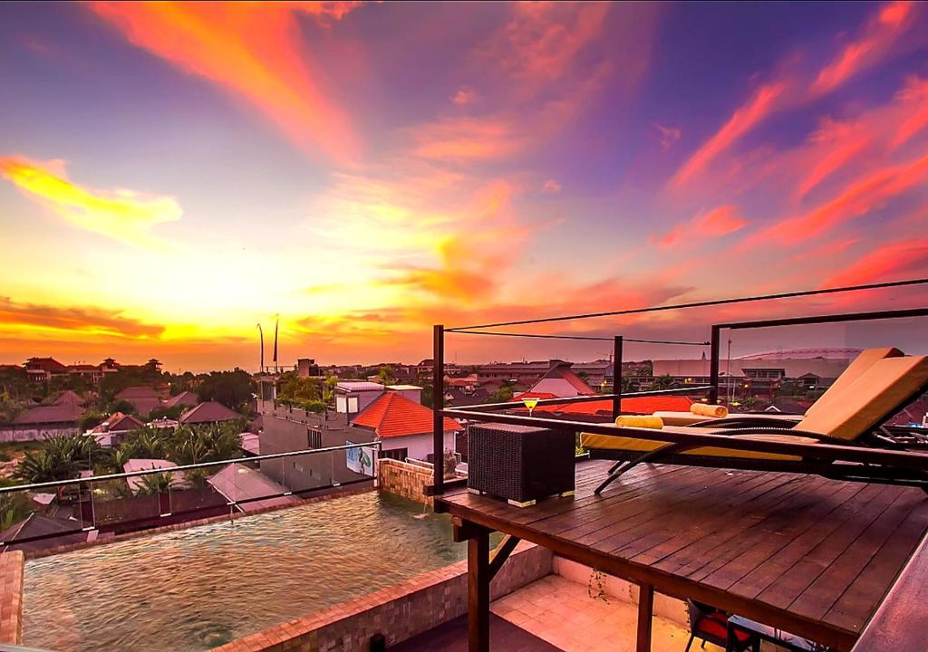 a balcony with a view of a sunset at Sky Suites in Seminyak