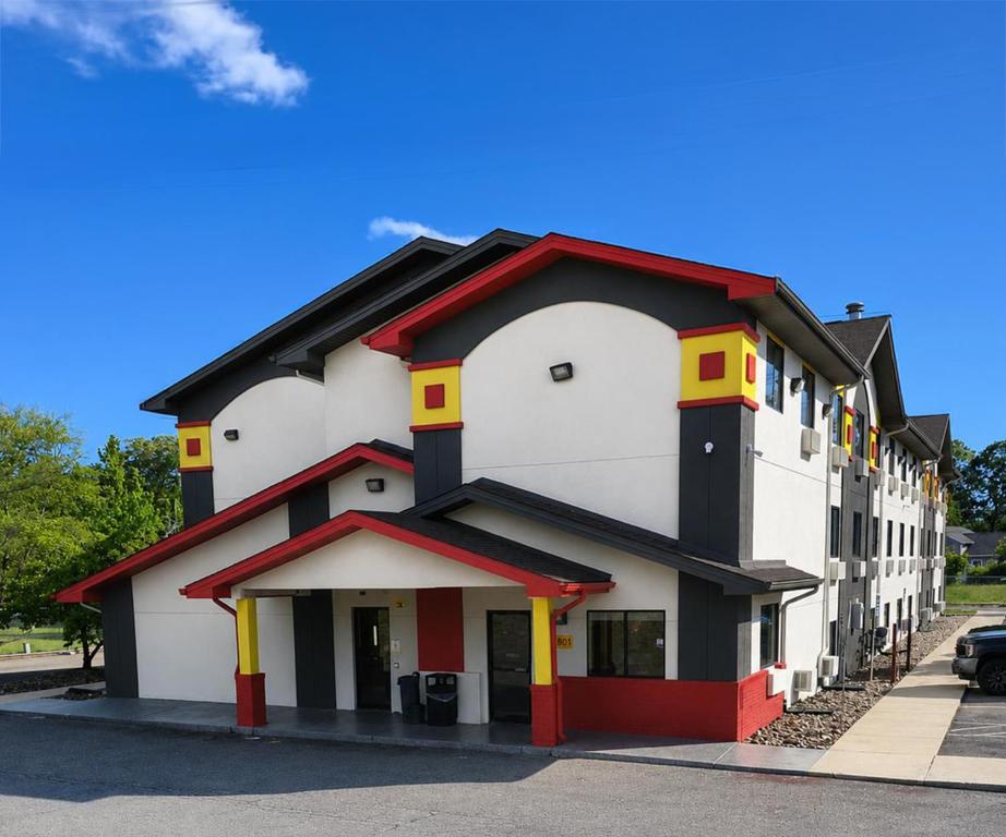 a large white building with red and yellow trim at Super 8 by Wyndham Lexington Park/California Area in California