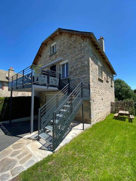 a stone building with a ramp leading to a house at Gîte de marthe in Sainte-Colombe-de-Peyre