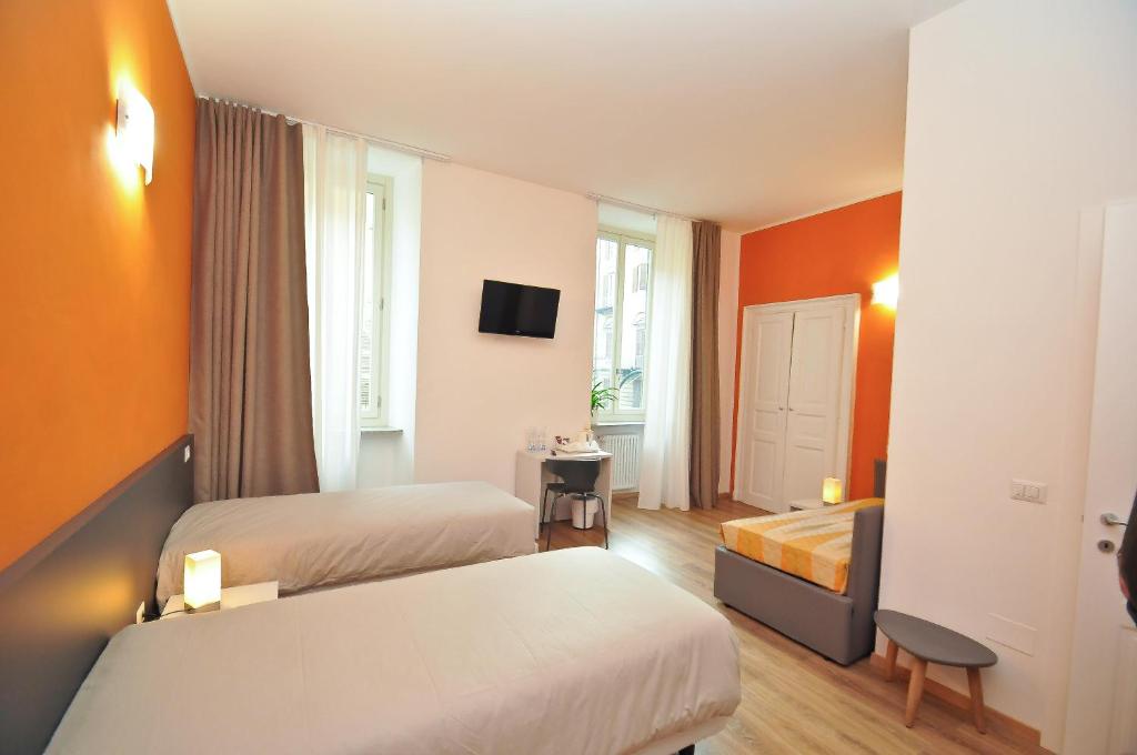 Habitación de hotel con 2 camas y TV en Torino 1854 Affittacamere, en Turín
