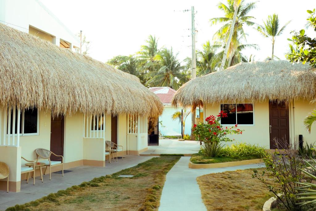 a resort with two thatched huts and a patio at Sunrise Beach Resort in Pooc