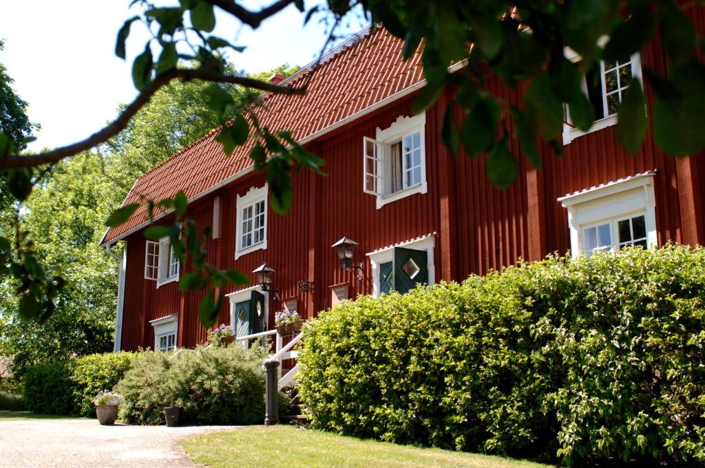 a red house with white windows and bushes at Steningevik in Märsta