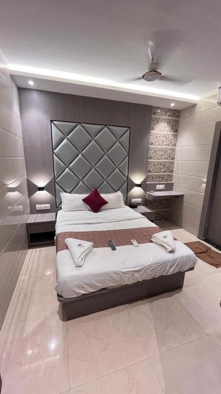 a large bedroom with a large bed with red pillows at Hotel Abrol in Mumbai