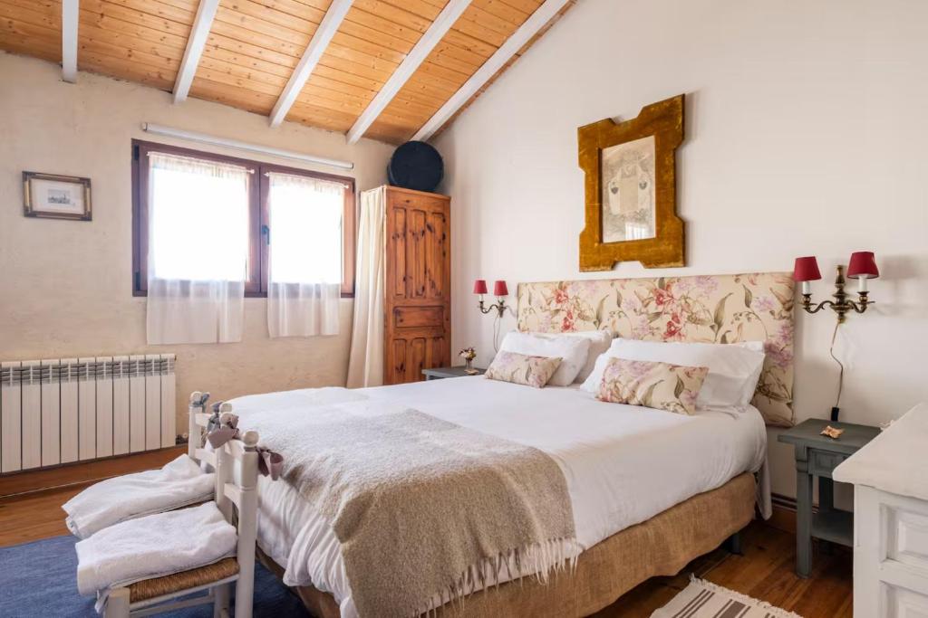 a bedroom with a large white bed and a window at Casa Valle del Lozoya in Rascafría
