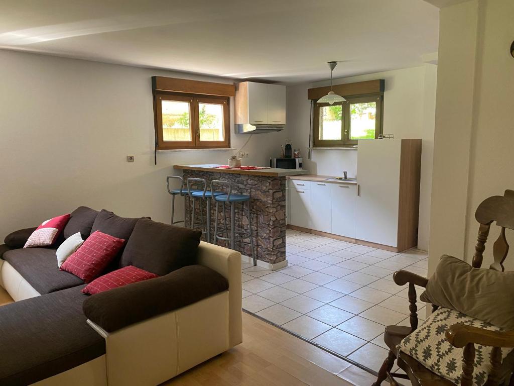 a living room with a couch and a kitchen at Côté Jardin in Bourgheim