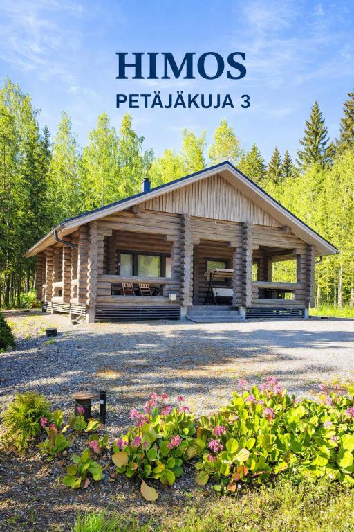 a wooden building with flowers in front of it at HIMOS Petäjäkuja 3 in Himos
