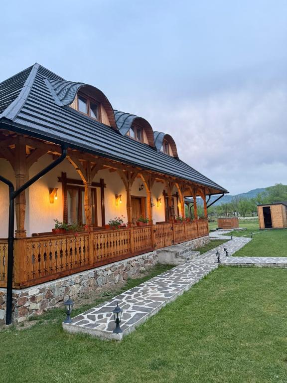 a large house with a porch and a fence at Casa Moroșanului Vișeu de Sus in Vişeu de Sus
