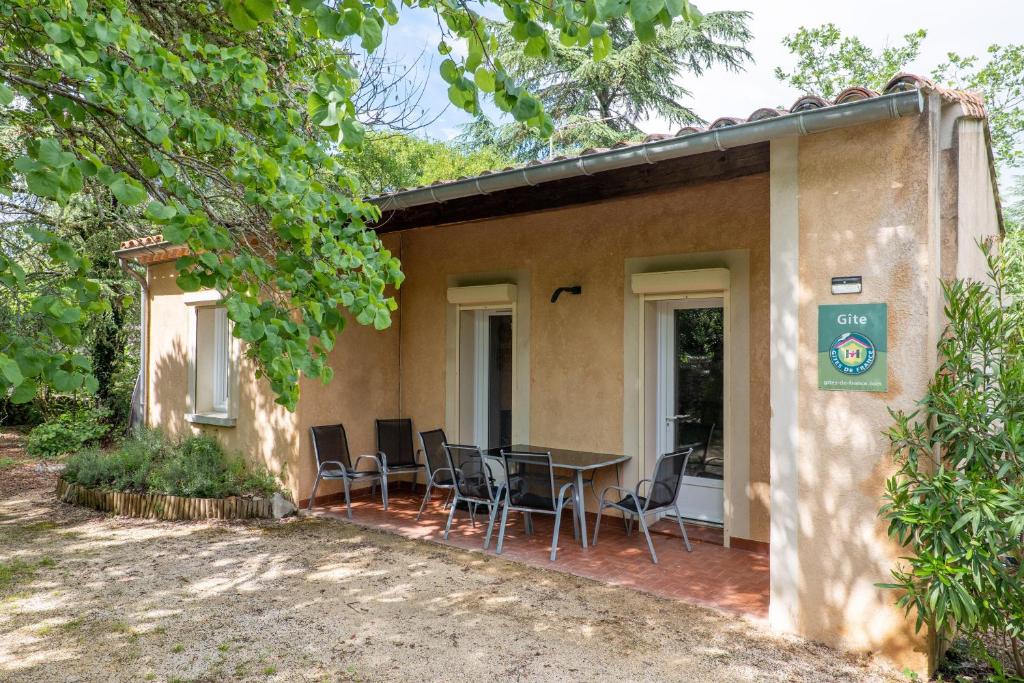 a house with a table and chairs outside of it at Gîte Le Mazet Des Campanes in Saint Alban Auriolles