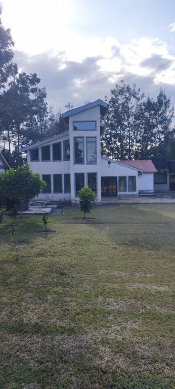 a large white building with a grass field in front of it at Ample Safari Tours in Mombasa