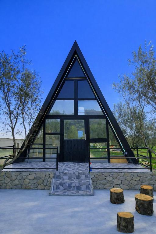a pyramid shaped building with windows and stools at Villa Olivia in Elbasan