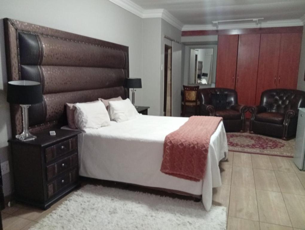 a bedroom with a large bed with a large headboard at Vukani Holdings Group in Vanderbijlpark