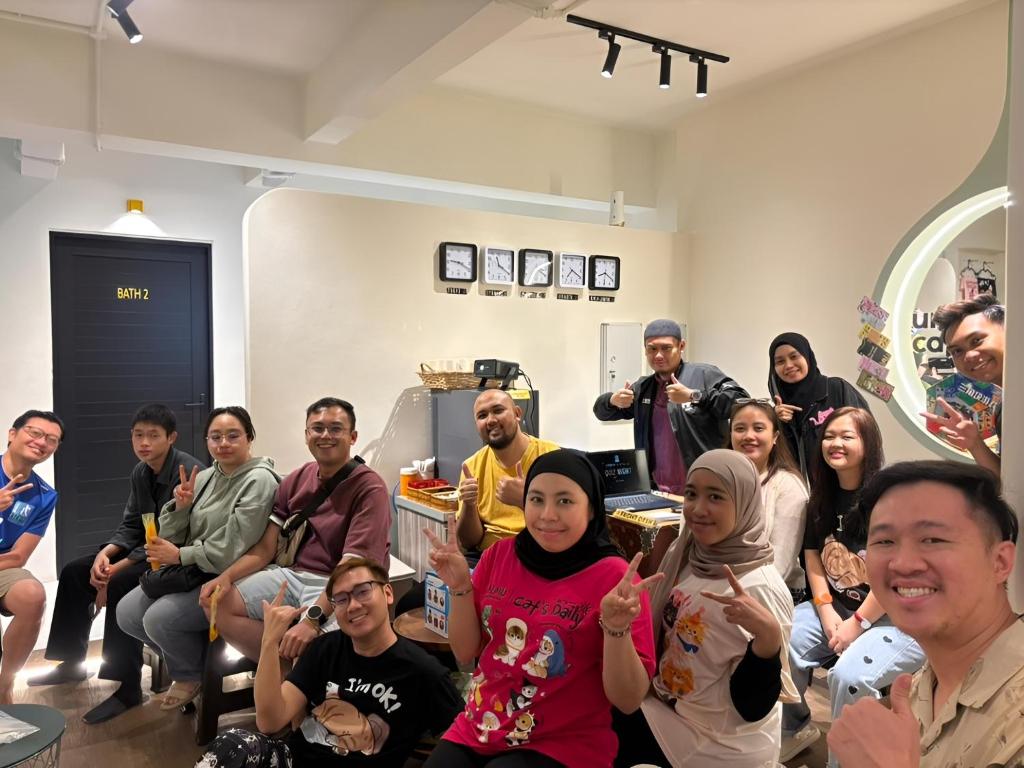 a group of people sitting in a room posing for a picture at Urban Capsule by Faradale in Kuching