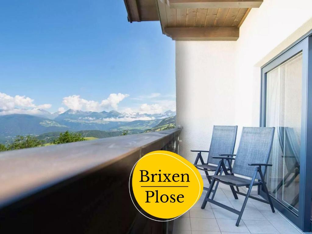two chairs on a balcony with a view of the mountains at Bergheim Plose - Appartements in St Andrä bei Brixen in Bressanone