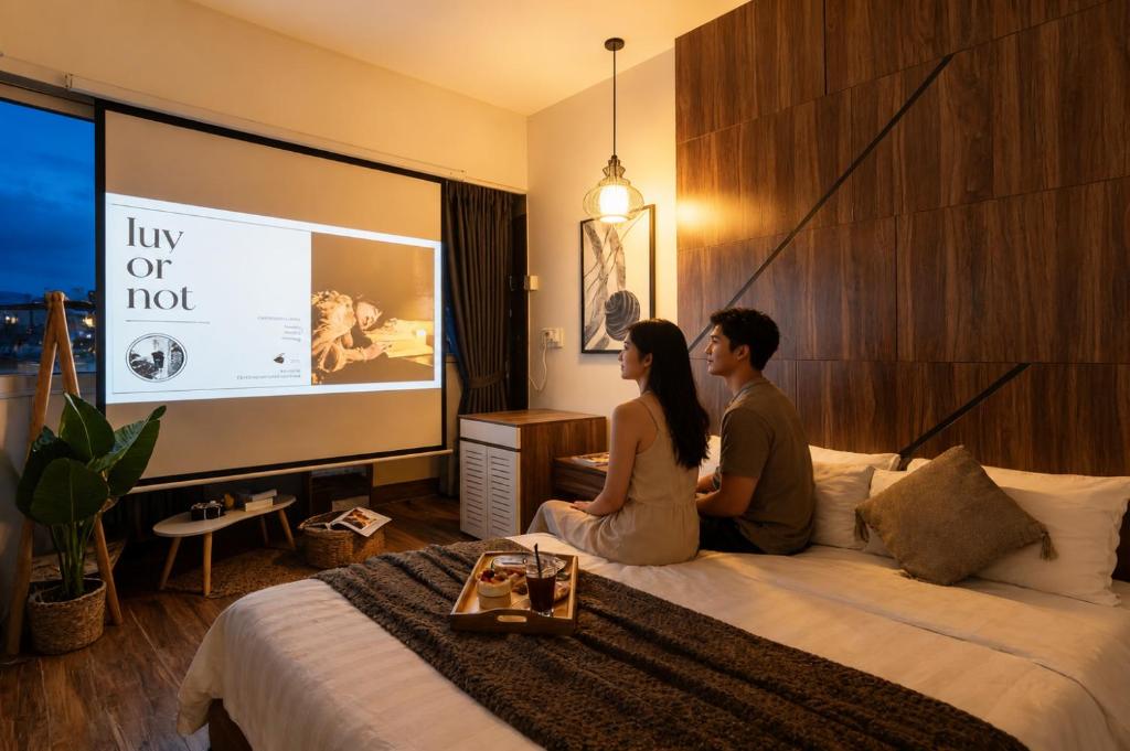 a man and woman sitting on a bed in a hotel room at The Morris City Central Boutique in Da Lat