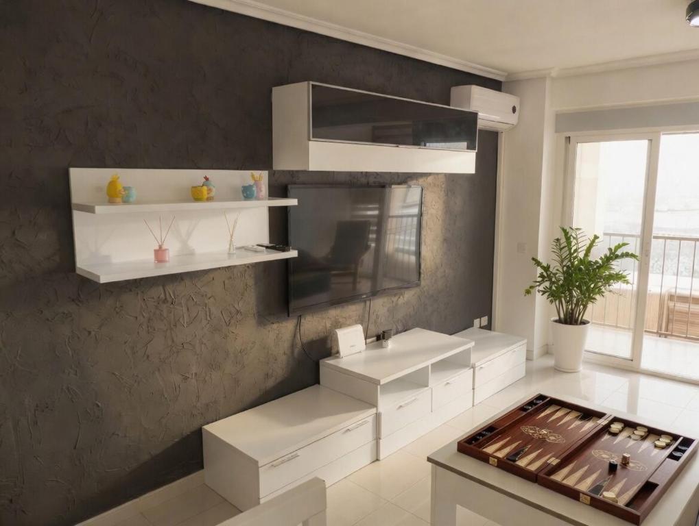 a kitchen with white cabinets and a sink and a wall at Piso Almería playa in Almería