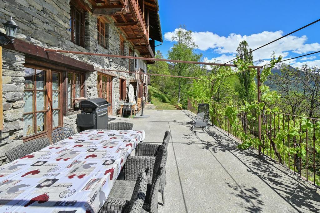 a table sitting outside of a building with a grill at La Ferme D'aurélie in Montvalezan