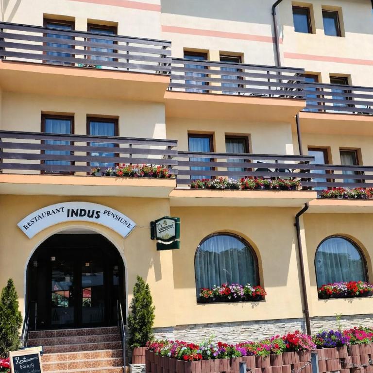 a building with flower boxes on the balconies at Pensiune Restaurant Indus in Ocna Sibiului