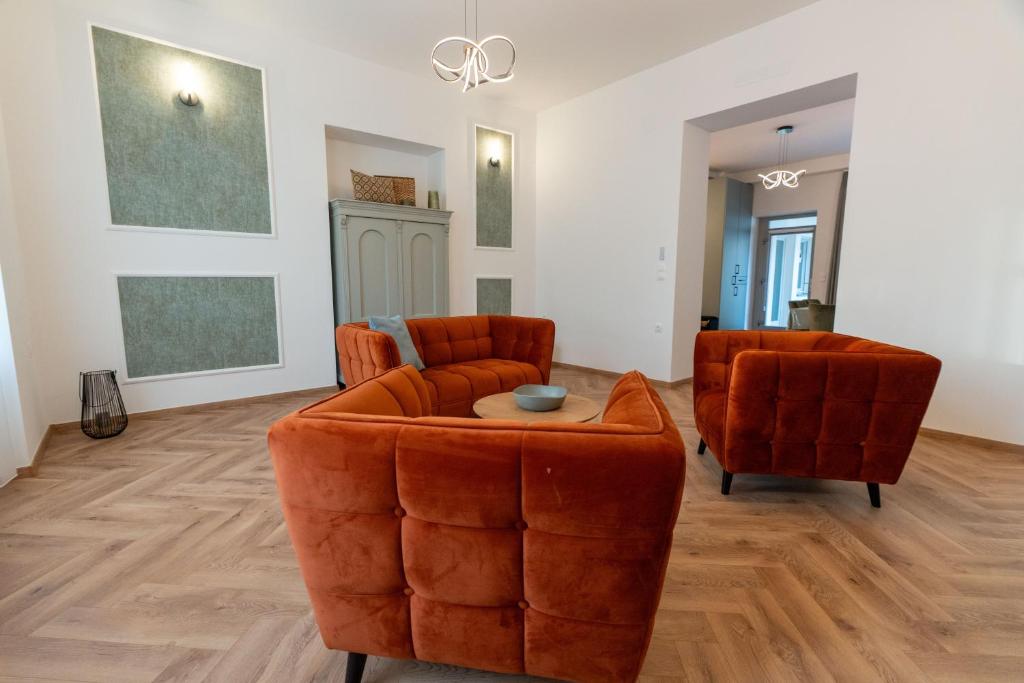 a living room with two orange chairs and a table at Jancsó Apartman in Dunaföldvár