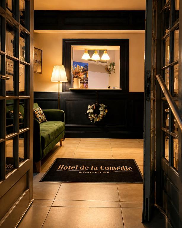 a living room with a green couch and a mirror at Hotel Comédie - Place De La Comédie Opéra in Montpellier