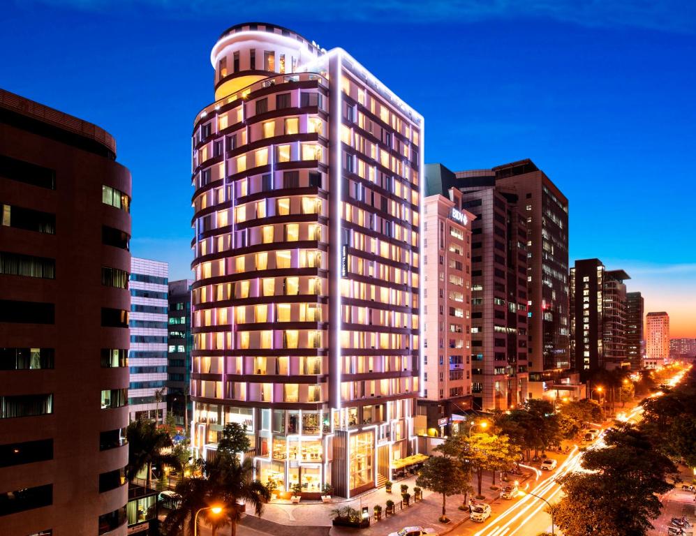 um edifício alto numa cidade à noite em Novotel Suites Hanoi em Hanói