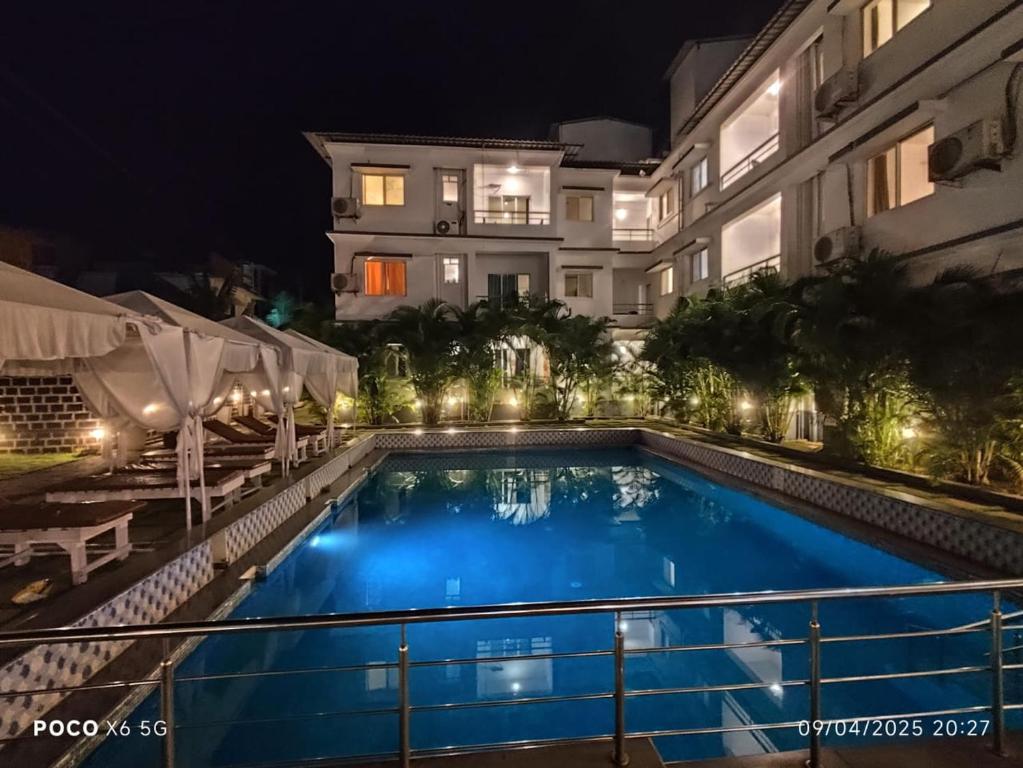 a swimming pool in front of a building at night at Rajdeep by Dacha Arambol in Arambol