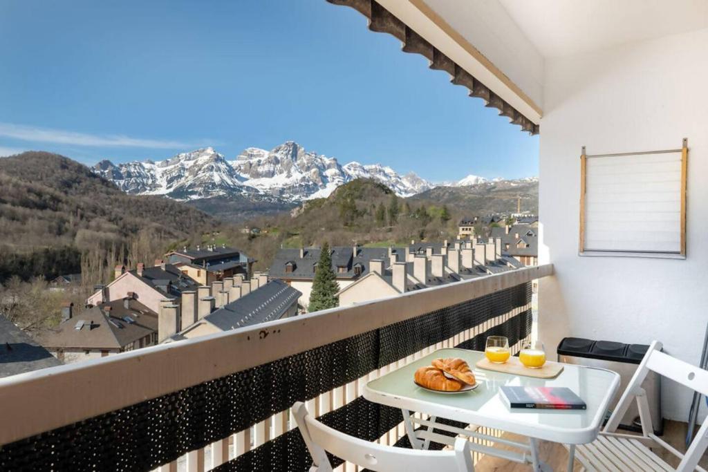 a balcony with a table and chairs and mountains at Relax en Pirineo l Vistas l Wifi l Balcón in Panticosa