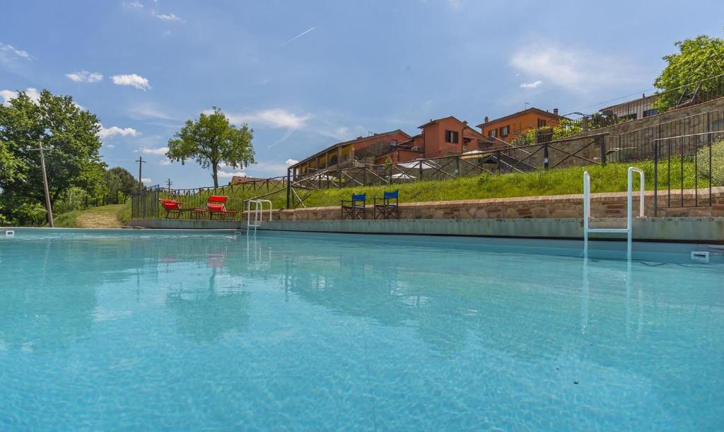拉泰里納的住宿－勒芳納奇假日公寓，一座大型游泳池,配有蓝色的水和红色的椅子