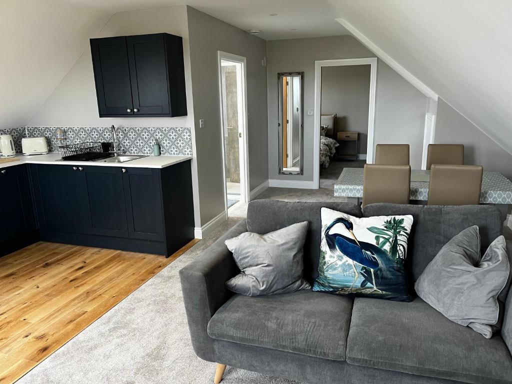 a living room with a couch and a kitchen at The loft in Tingewick