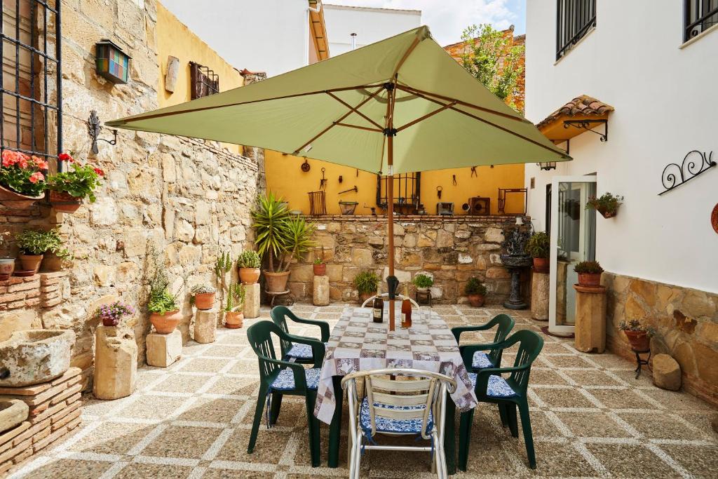 a table and chairs with an umbrella on a patio at Casa Emilia in Baeza
