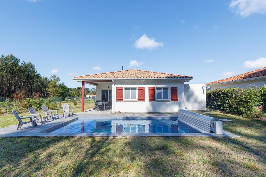 a pool in the backyard of a house at Villa Bourdaines - Conciergerieland in Vielle-Saint-Girons