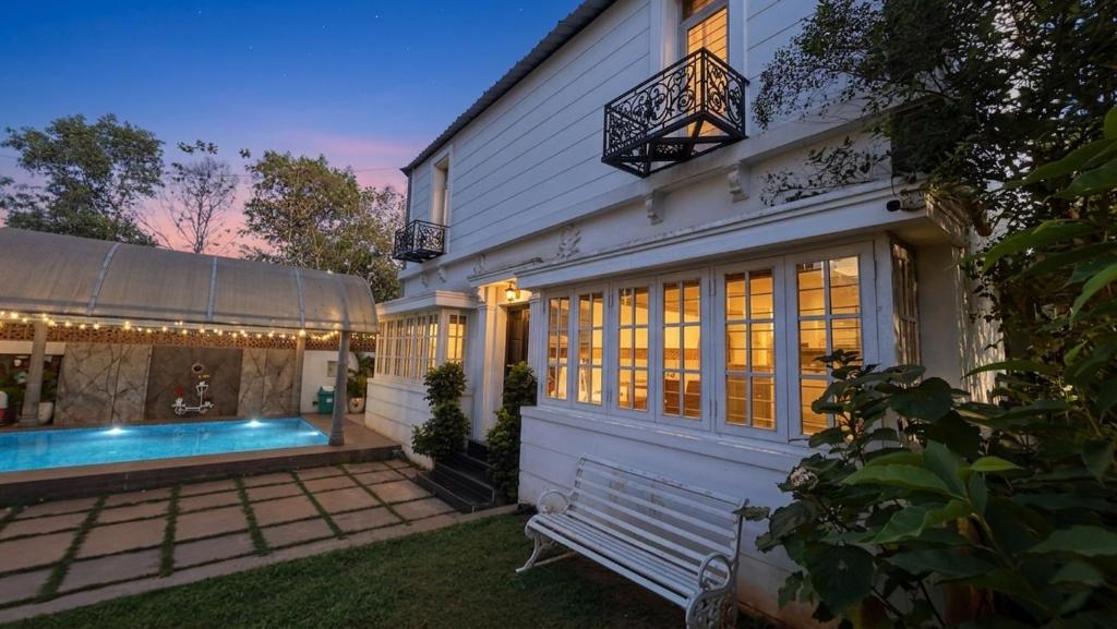 a white house with a swimming pool in the yard at De Majestic Grand Villa in Auroville