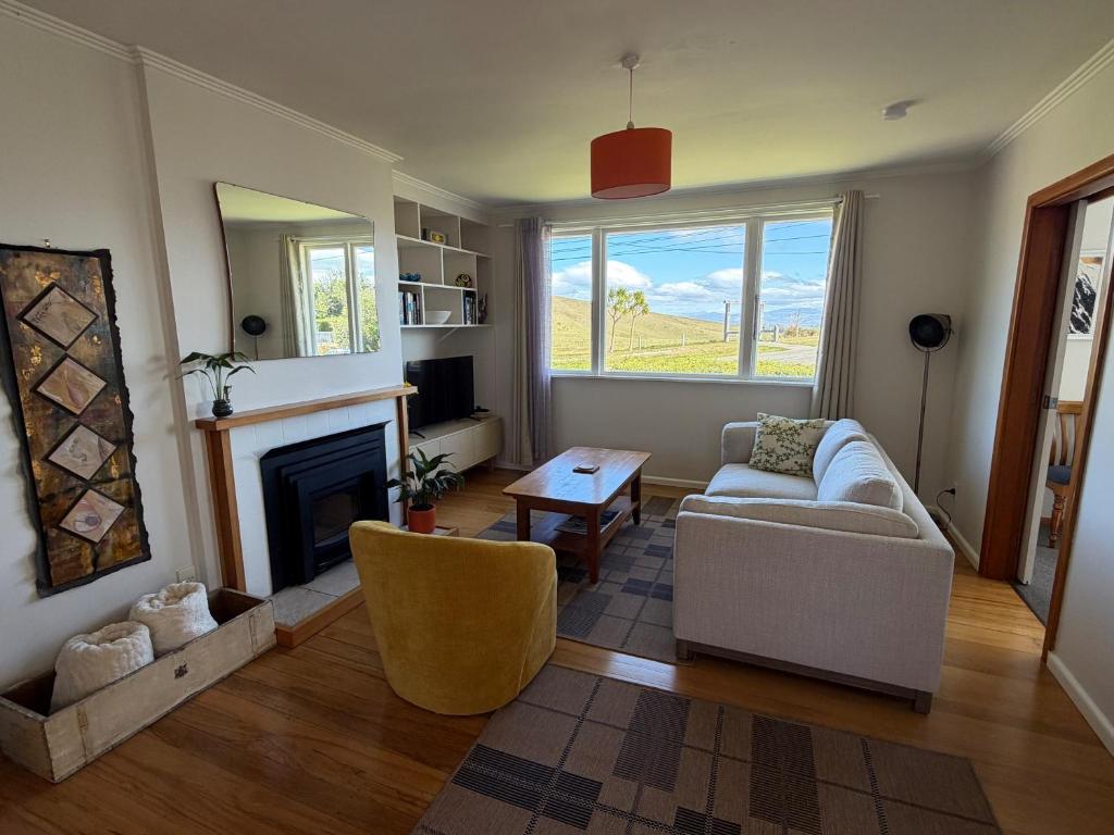a living room with a couch and a fireplace at Tyne above Town in Oamaru