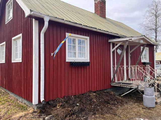 a red house with a flag on the side of it at Fyrås Gård Tallstugan in Fyrås