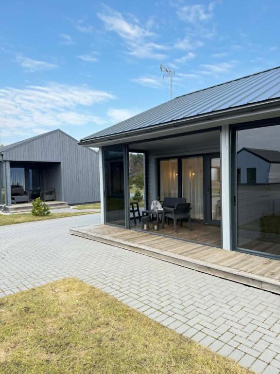 a house with glass doors and a patio at Navi Jūra House13 in Palanga