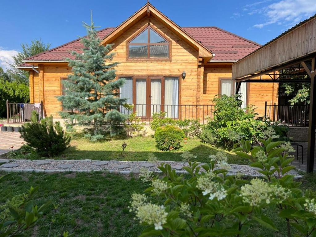a house with a christmas tree in the yard at Нур Срубы Сары Ой in Chon-Sary-Oy