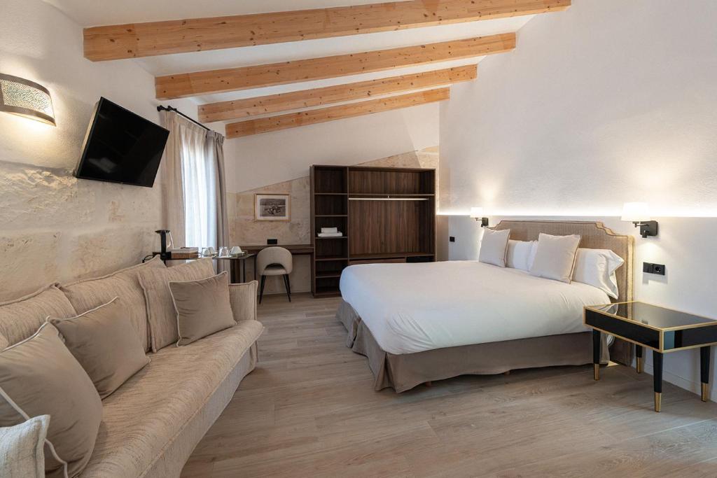 a hotel room with a bed and a couch at Sa Pobla Rooms Ex Flor de Mandarina in Sa Pobla