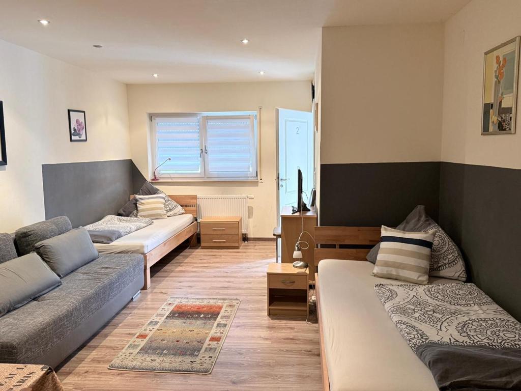 a living room with three beds and a couch at Ferienwohnungen am Main in Erlabrunn