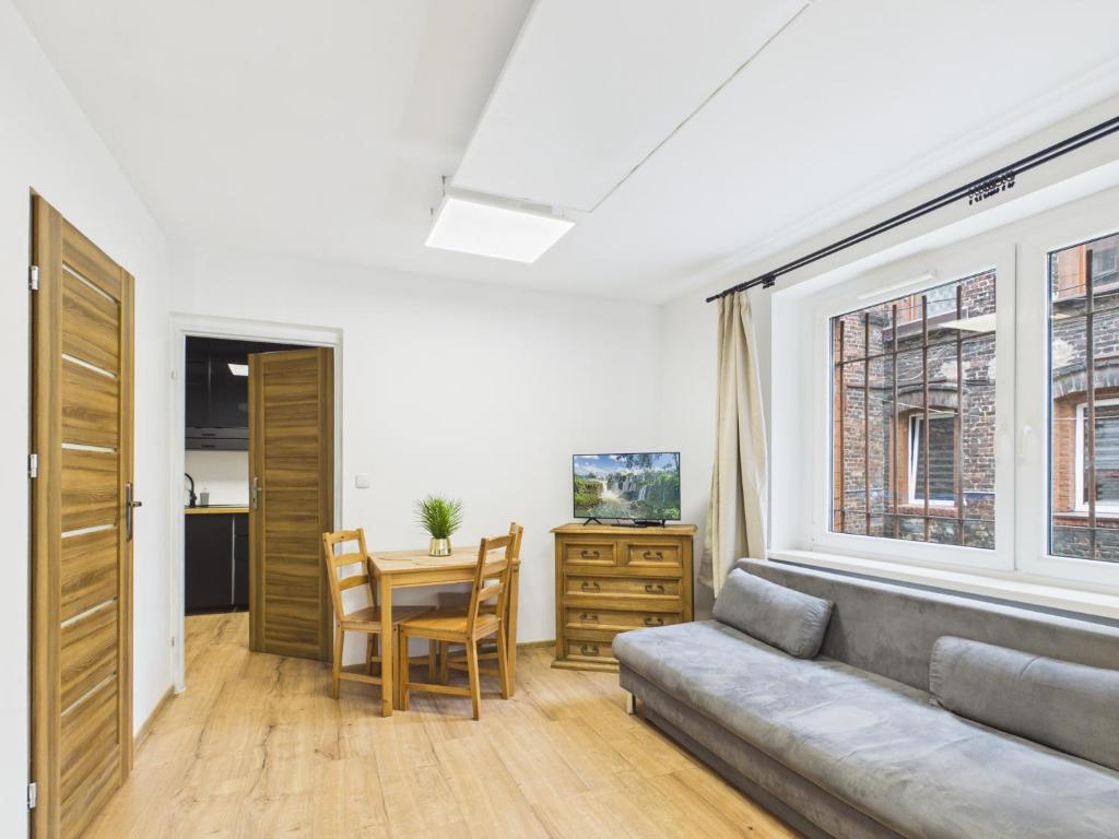 a living room with a couch and a table at Apartamenty Retro Loft in Chorzów