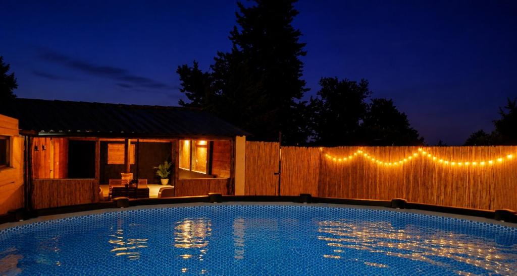 a swimming pool at night with lights on a fence at Finca Sueño Crea in Lorca