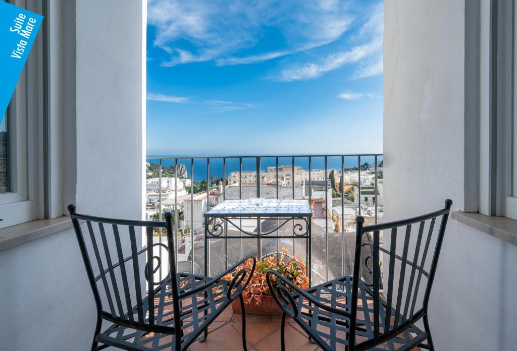 a balcony with two chairs and a table on a balcony at Casa Leucosia Suites in Capri