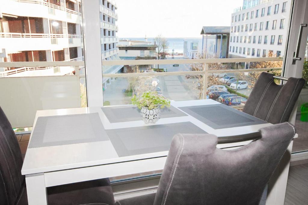 a white table and chairs with a view of a street at Brandungsbad 36 in Grömitz