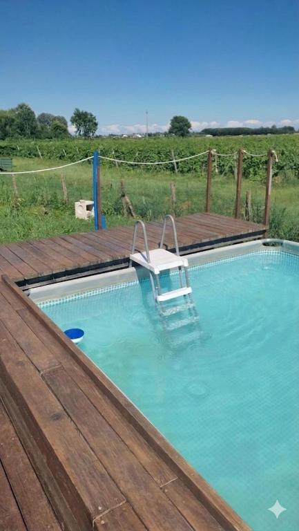 a boat in a swimming pool with a wooden deck at Tenuta Crescentini-ValleMura ,appartamenti con entrata indipendente in San Donà di Piave