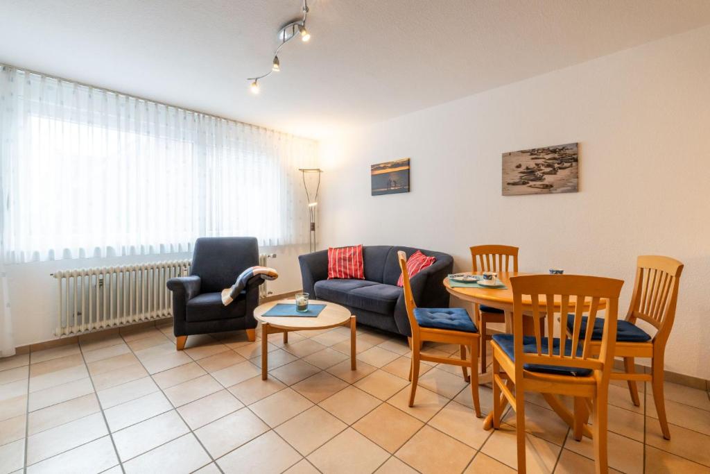 a living room with a couch and a table and chairs at Ferienwohnung Bäumer Borkum - Nichtraucher & allergikerfreundlich in Borkum