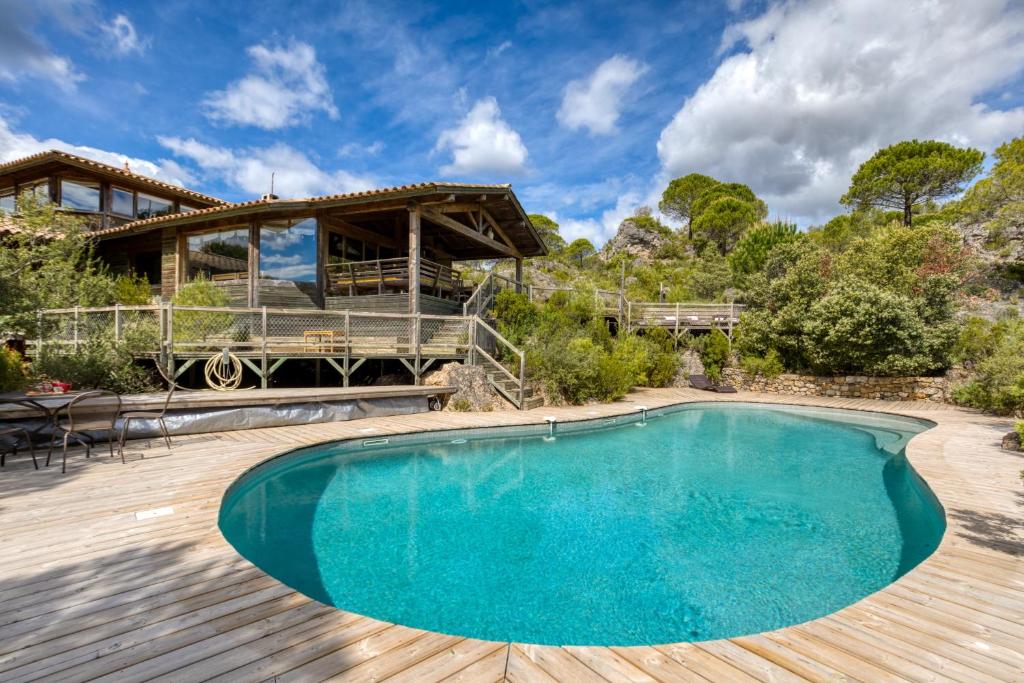 a pool on a wooden deck with a house at Villa dans Site Exceptionnel in Mourèze