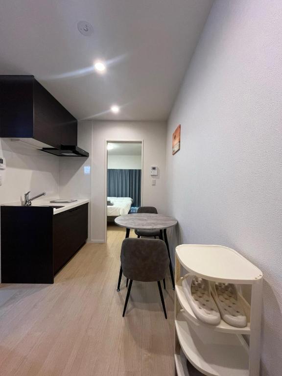a room with a table and two chairs and a kitchen at Hotel Suite 2 in Warabi