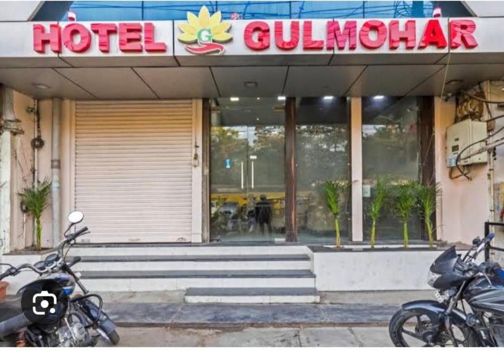 two motorcycles parked in front of a hotel building at Hotel Gulmohar in Indore