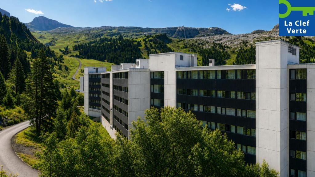 a building with a road in front of a mountain at Résidence Pierre & Vacances La Forêt in Flaine