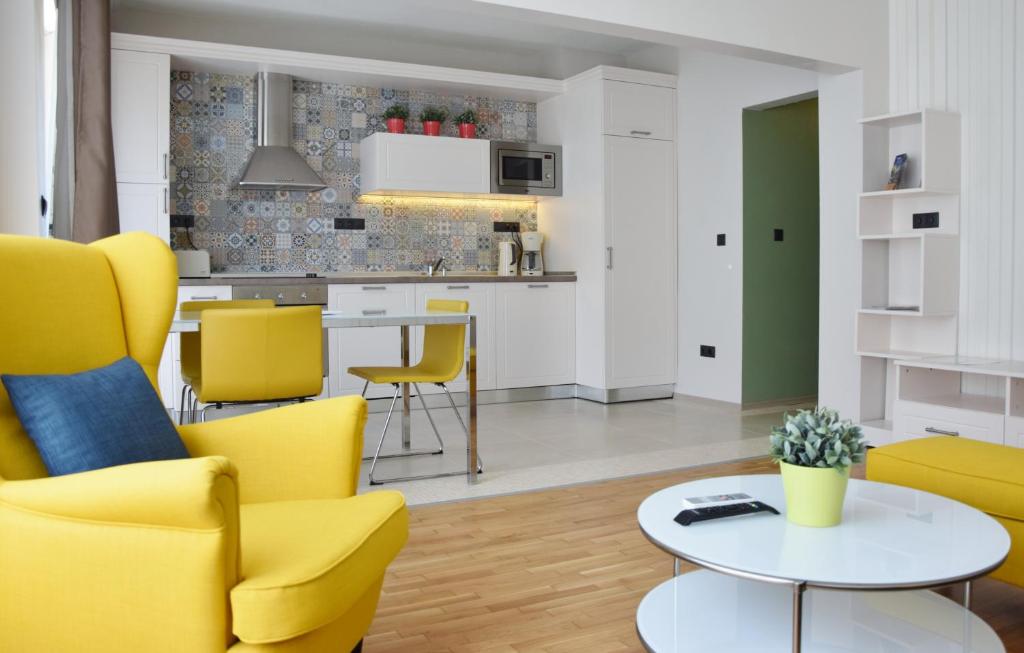a living room with yellow chairs and a table at VIP Apartments Sofia in Sofia