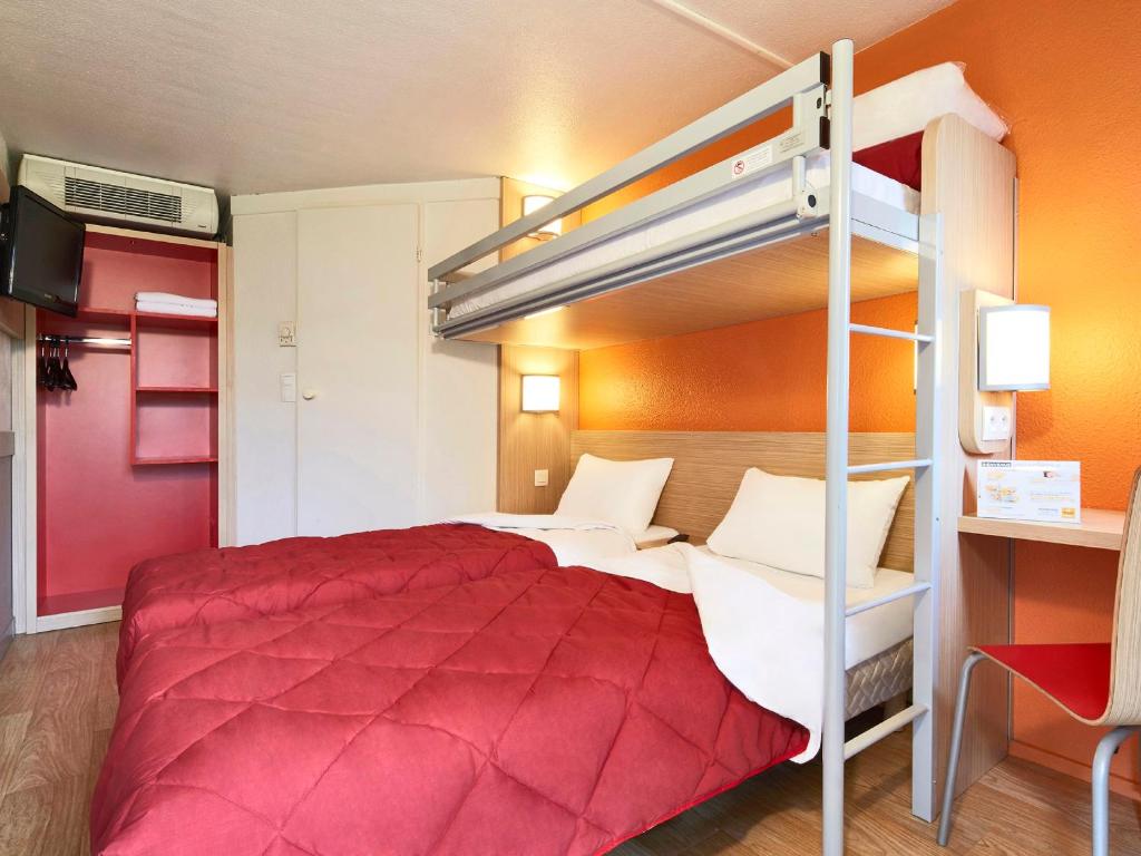 - une chambre avec un lit rouge et des lits superposés dans l'établissement Premiere Classe Boissy St Leger, à Boissy-Saint-Léger