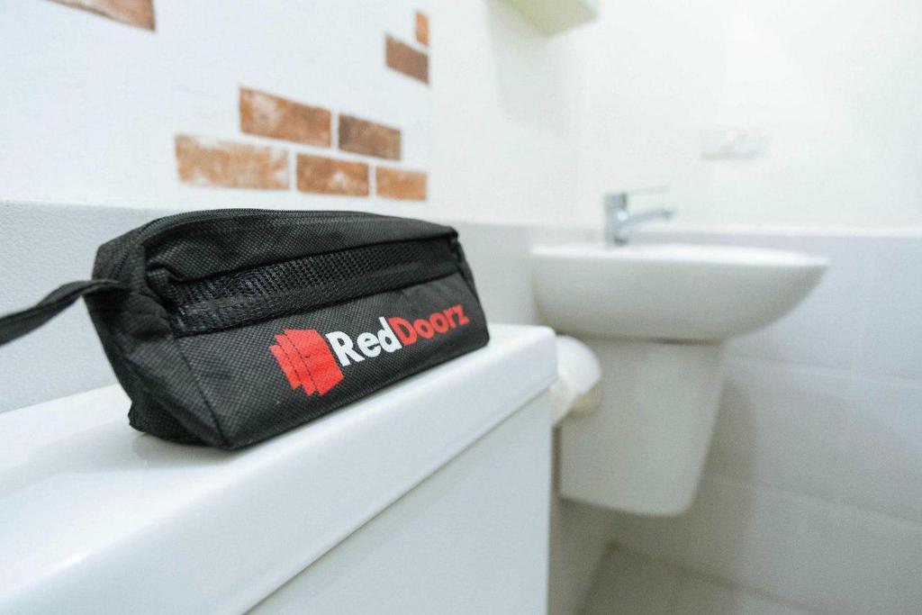 a black bag sitting on a counter in a bathroom at RedDoorz @ Kisaran Kota in Kisaran